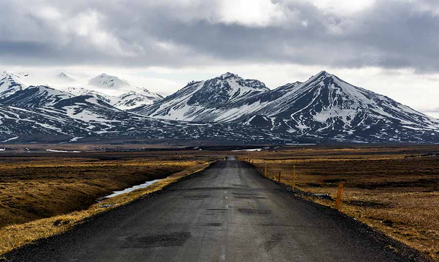 Scenic road leading through Vatnajokull National Park in Iceland with snow-capped mountains and open landscapes