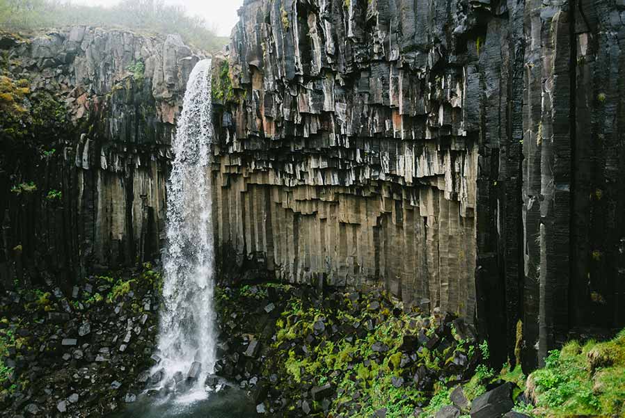 Svartifoss Waterfall cascading down basalt columns in Skaftafell, Vatnajökull National Park, Iceland, a popular destination for nature enthusiasts.