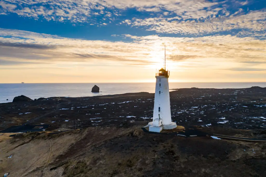 Aerial view of Reykjanesviti lighthouse at sunset, surrounded by the rugged landscape of the Reykjanes Peninsula in Southern Iceland.