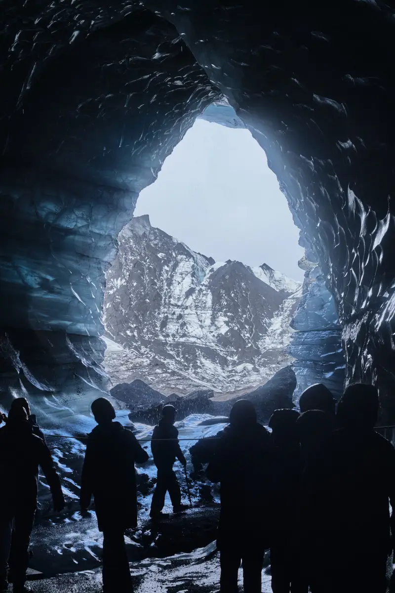 Explorers marvel at the ethereal blue ice formations inside Katla Glacier Ice Cave, a popular tourist attraction in Iceland