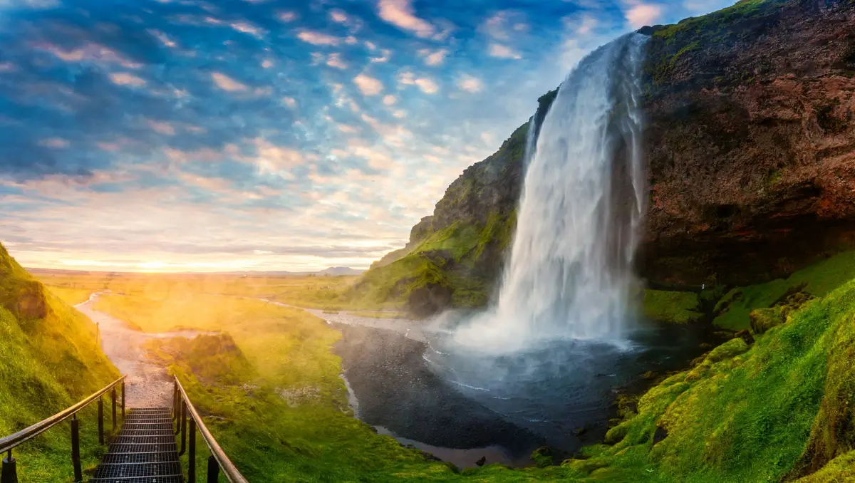 Seljalandsfoss Waterfall in Iceland at sunset with flowing water and vibrant landscape, a popular tourist attraction perfect for private tours.